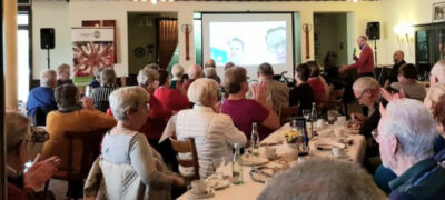 Publikum im Saal vor einer Leinwand