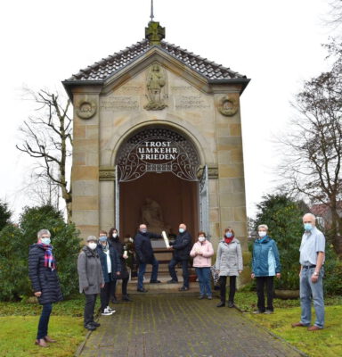 Personen stehen vor einer Kapelle